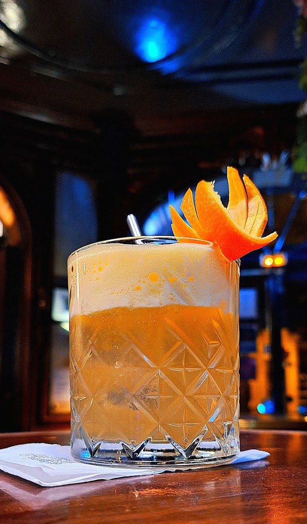 Un cocktail orangé garni d’un zeste